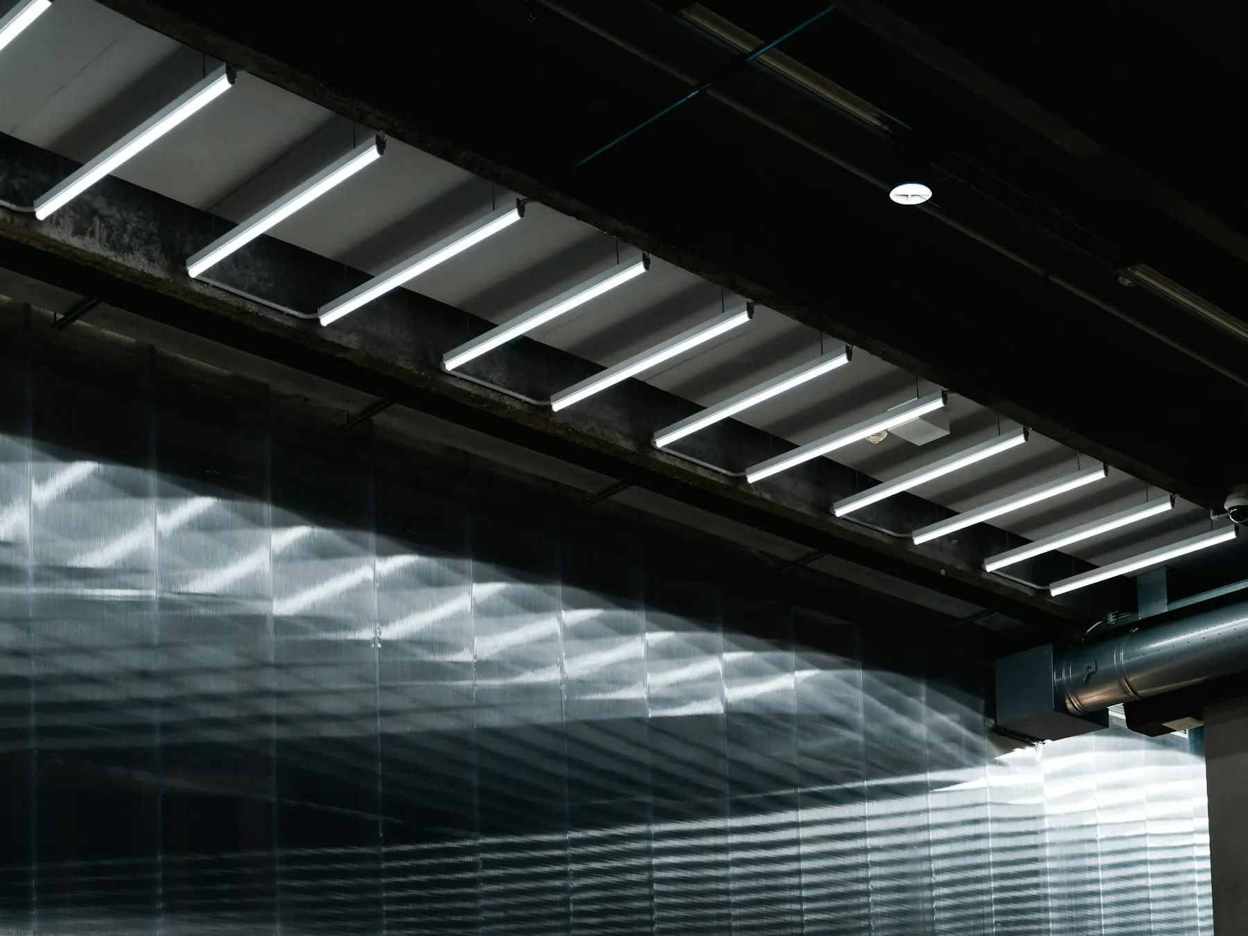 Hallendecke einer Kfz-Werkstatt mit neuen, eingeschalteten LED-Hallenleuchten