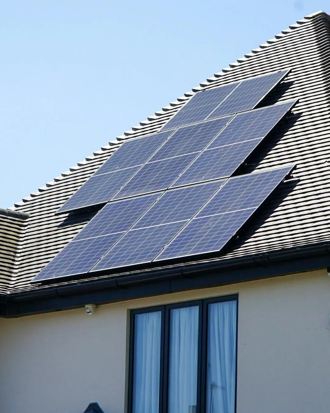 Solarmodule auf dem Satteldach eines Einfamilienhauses bei klarem Himmel
