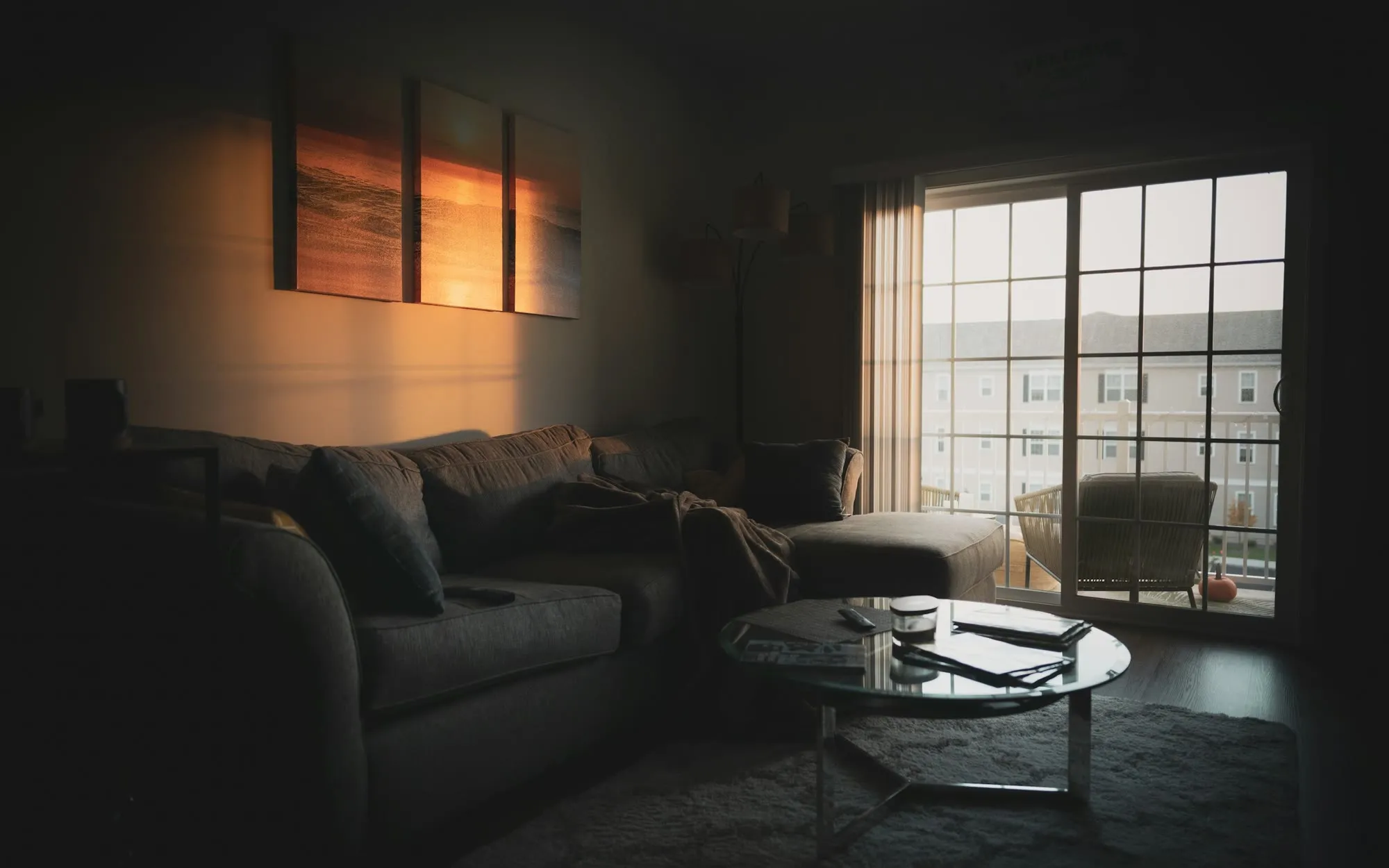 Wohnzimmer am Abend mit halb geschlossenen Rollläden und warmem, gedimmtem Licht